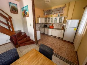 a kitchen with white cabinets and a table and a refrigerator at Maytenus Galapagos in Puerto Ayora +36 photos