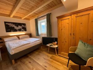 a bedroom with a bed and a chair at Mas dal Vent in Valfloriana