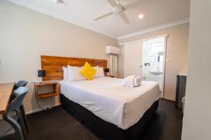a bedroom with a large bed and a desk and a table at Nowra Motor Inn in Nowra +44 photos