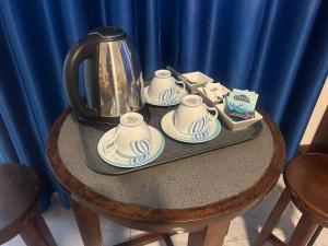a tea kettle and saucers on a table at Lilly Rooms in Kandy