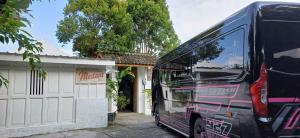 a black bus parked in front of a garage at Mertanihuisjogja in Salakan
