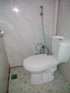 a bathroom with a toilet with a hose attached to it at Banyuwangi Homestay in Banyuwangi