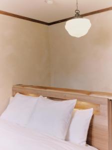 a bedroom with a bed with a wooden headboard at Casa Bianca in Hakuba