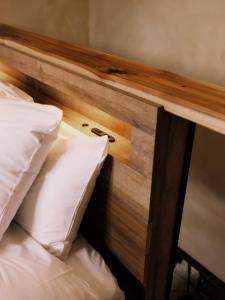 a bed with a wooden headboard and two pillows at Casa Bianca in Hakuba