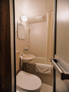 a small bathroom with a toilet and a sink at Casa Bianca in Hakuba