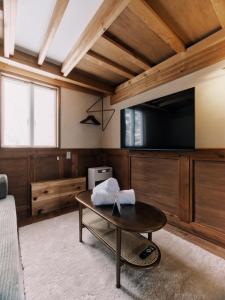 a living room with a coffee table and a flat screen tv at Casa Bianca in Hakuba +29 photos