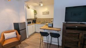 a small kitchen with a table and chairs and a television at Studio Speedway in Tucson