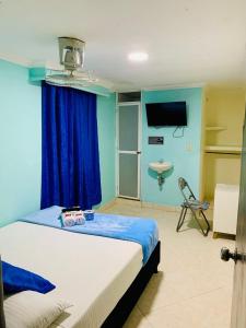 a bedroom with a bed with a blue wall at Hotel Viajero Del Mar in Turbo
