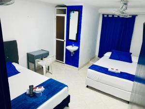 a hotel room with two beds and a sink at Hotel Viajero Del Mar in Turbo +16 photos