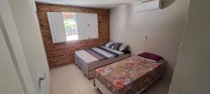 a small room with two beds and a window at Meu refúgio in Japaratinga +4 photos