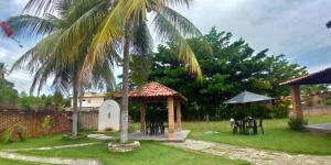 a garden with a gazebo and a palm tree at Meu refúgio in Japaratinga