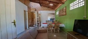 a room with a green wall and a table and chairs at Meu refúgio in Japaratinga