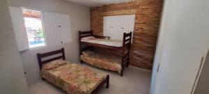 a small room with two bunk beds and a window at Meu refúgio in Japaratinga