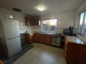 a kitchen with a white refrigerator and a sink at Oikos Arriendos in Futrono +2 photos