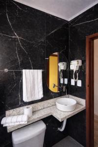 ein Badezimmer mit Waschbecken, Toilette und Spiegel in der Unterkunft Casa Sol da Ilha in Angra dos Reis