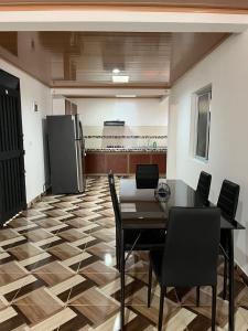a dining room with a table and chairs and a refrigerator at Aparta hotel Betania in Quimbaya