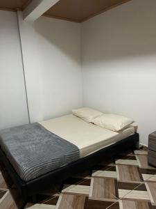 a bed in a room with a white wall at Aparta hotel Betania in Quimbaya