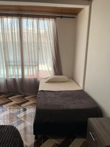 a bedroom with a bed and a large window at Aparta hotel Betania in Quimbaya