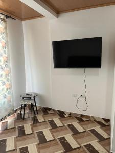 a living room with a flat screen tv on a wall at Aparta hotel Betania in Quimbaya