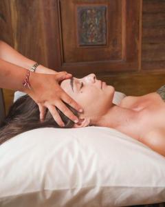 a man getting a massage in a bed at Pondok Pitaya Balian Hotel in Selemadeg