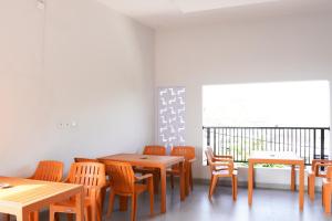 a room with tables and chairs and a window at RedDoorz Plus Syariah at Umyas Hotel near Terminal Anjuk Ladang Nganjuk in Nganjuk