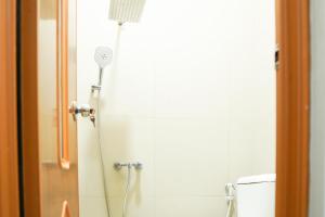 a shower in a bathroom next to a toilet at RedDoorz Plus Syariah at Umyas Hotel near Terminal Anjuk Ladang Nganjuk in Nganjuk +62 photos