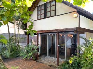 a house with glass doors and a deck at Moana Waterfront Bungalow in Punaauia +12 photos