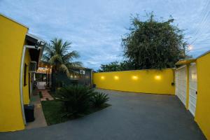 a yellow wall with lights on it next to a driveway at Villa Kanindé Bonito in Bonito