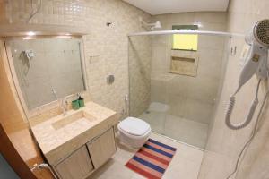 a bathroom with a shower and a toilet and a sink at Villa Kanindé Bonito in Bonito +13 photos