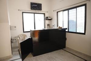 a kitchen with a black counter and two windows at Shree mahal in Jāmb