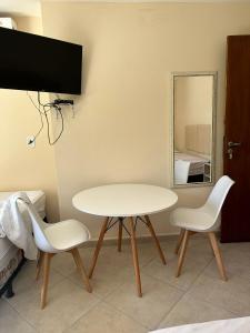 a white table and two chairs and a mirror at Ecopousada Garten Haus in Santa Teresa