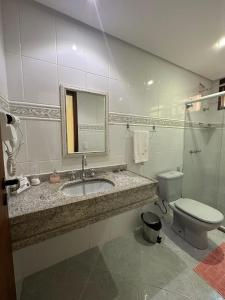 a bathroom with a sink and a toilet and a mirror at Ecopousada Garten Haus in Santa Teresa +49 photos