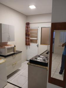 a kitchen with a stove and a microwave at Kitnet 4 Vila Lunardi in Campinas