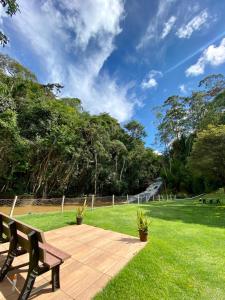 a park with a bench in the grass at Ecopousada Garten Haus in Santa Teresa