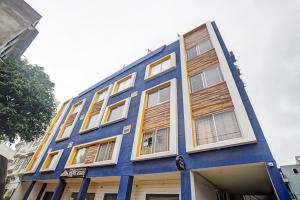a blue building with wooden shuttered windows at Townhouse Pine Tree in Indore