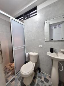 a bathroom with a toilet and a sink at Nuevo y Confortable Apartamento in Florencia