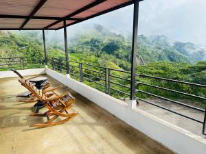 a balcony with chairs and a view of the mountains at HOTEL DEL MINERO Otanche in Otanche