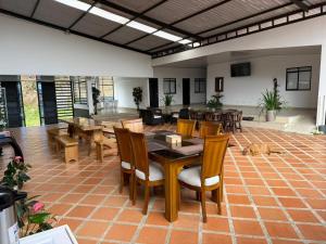 a room with tables and chairs and a dog laying on the floor at HOTEL DEL MINERO Otanche in Otanche