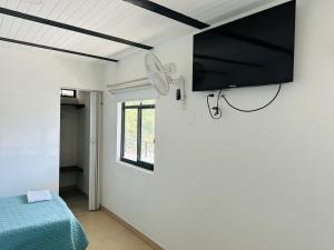 a room with a bed and a tv on the wall at HOTEL DEL MINERO Otanche in Otanche