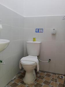 a bathroom with a white toilet and a sink at KG Hotel in Kampong Sorosob +3 photos