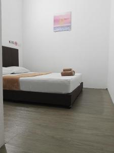 a bedroom with a bed in a white room at KG Hotel in Kampong Sorosob