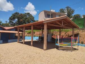 a wooden pergola with a playground and a swing at Casinha Virtuosa in Monte Sião