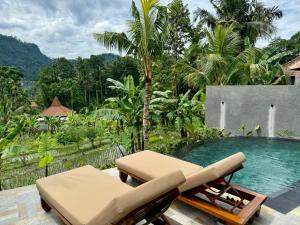 a pool with a chaise lounge and a chair next to it at Wanataru Sidemen Villas in Sidemen