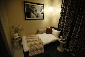 a small bedroom with a bed and a picture of a woman at The Crescent Hotel Beverly Hills in Los Angeles +9 photos