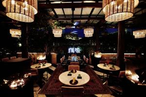 a restaurant with tables and chairs and chandeliers at The Crescent Hotel Beverly Hills in Los Angeles