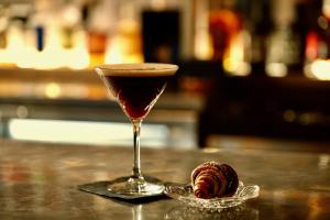 a drink in a glass next to a pastry on a table at The Crescent Hotel Beverly Hills in Los Angeles