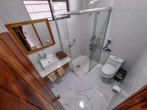 a bathroom with a shower and a toilet and a sink at Maytenus Galapagos in Puerto Ayora