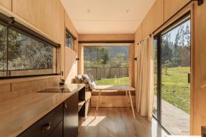 a kitchen with a large window in a tiny house at Earth Tones Tiny Homes & Suites in Ollantaytambo