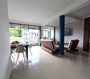 a living room with a table and chairs and a blue pole at Nuevo y Confortable Apartamento in Florencia