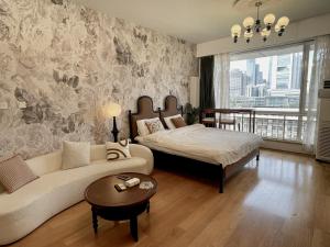 a living room with a couch and a bed at Anju Apartment in Beijing